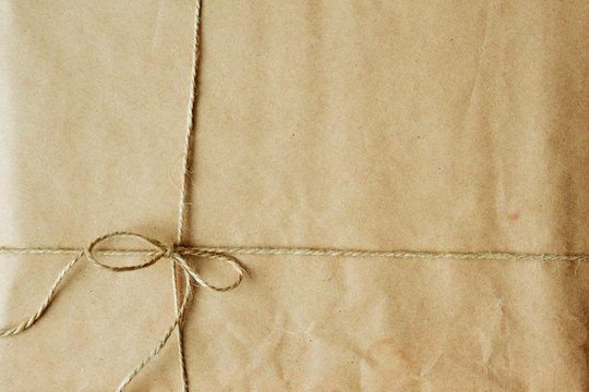 Overhead view of a single holiday package wrapped with eco friendly craft paper and tied with twine.