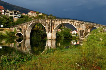 old stone bridge and reflection on river