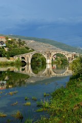 Fototapeta na wymiar reflection of a stone bridge in a river