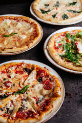 Traditional Italian pizza on a dark background top view copy space.