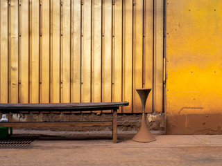 黄色い工場の壁とベンチ