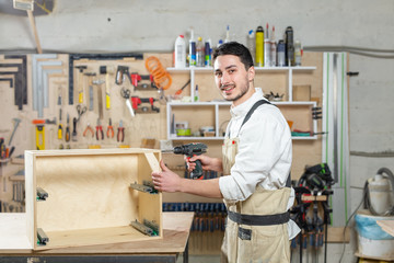 furniture factory, Small-Sized Companies and people concept - Young worker works in a factory for the production of furniture