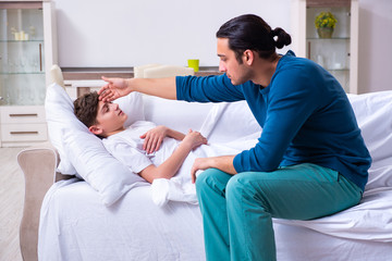 Obraz premium Young father caring for sick son