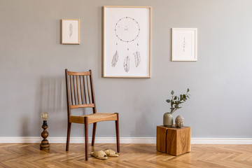 Stylish bohemian interior design of living room with retro chair, rattan slippers, wooden cube, retro lamp, flowers, mock up poster frames and elegant accessories. Modern home decor. Template.