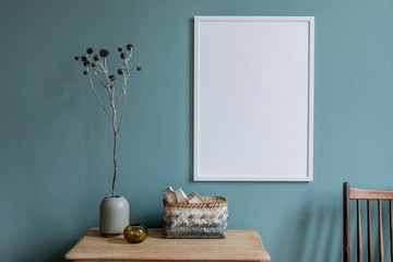 Stylish and minimalistic composition of sitting room with white mock up frame, wooden shelf,...