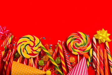 Colorful candies on a red  background. Lollipop. Top view. Copy space.