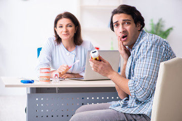Young man visiting female doctor stomatologist