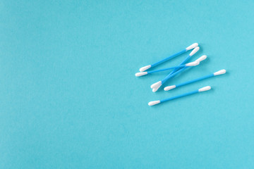 Cotton ear sticks for personal hygiene on blue background. Healthcare tools. Empty space for text.