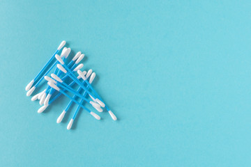 Cotton ear sticks for personal hygiene on blue background. Healthcare tools. Empty space for text.