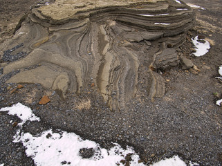 Ein von Lava geformter Felsen in Island mit Schnee