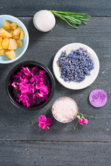 pink linaria flowers and bath salt, dried lavender buds on black wood table