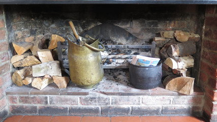 Firewood stacked in large open fire place in rural country pub