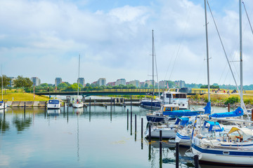 Beautiful yachts in the parking lot on the canal, against the backdrop of Malmo architecture.