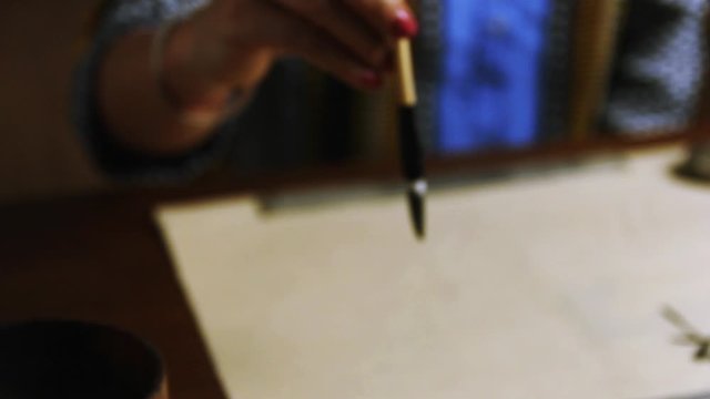 Girl writes Chinese characters (Translation from Chinese Mandarin 1: jixiang ruyi wanshi ankang- to be gratified propitiously with everything in good health, 2: fugui jixiang: wealthy and propitious)