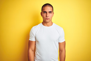 Young caucasian man wearing casual white t-shirt over yellow isolated background depressed and worry for distress, crying angry and afraid. Sad expression.