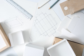 Development design drawing packaging. Desktop of a creative person making cardboard boxes. - 289823761