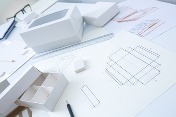 Development design drawing packaging. Desktop of a creative person making cardboard boxes. - 289823977