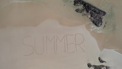 Aerial from the beach in Summer written in words in the sand