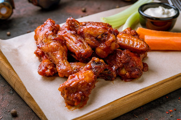 chicken wings in barbecue sauce and with blue cheese sause on dark rustic concrete table - 289824747