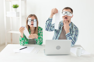 Finance and funny concept - Husband and wife in shock from numerous of checks and heavy expenses.