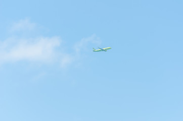 Naklejka na ściany i meble light green plane flies without leaving a trace on the background of the blue sky