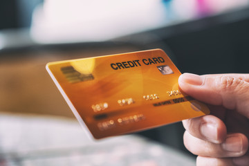 Closeup image of a hand holding and giving credit card