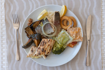 Various food on a white plate, closeup, top view