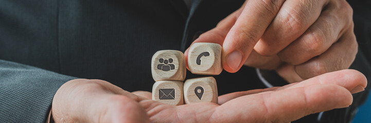 Customer service representative holding wooden dices with contact
