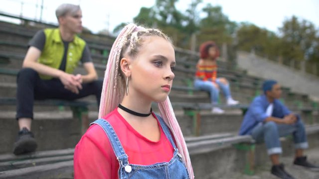 Stylish caucasian teenager sitting outdoors, awkward age problems, puberty