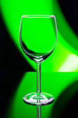 empty wine glass on green light background