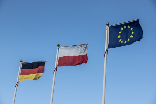 three flags in windy blue sky