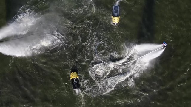 people perform complex tricks on flyboards.