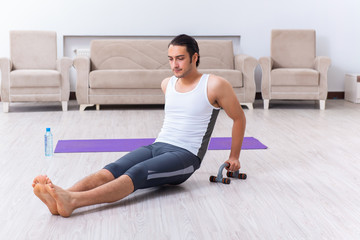 Fototapeta premium Young man training and exercising at home