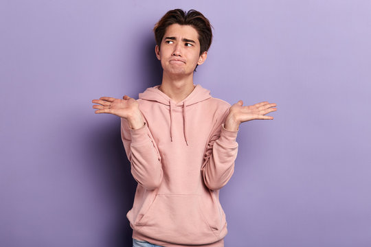 puzzled serious student doesn't know the answer of the question. close up photo. isolated blue background, studio shot