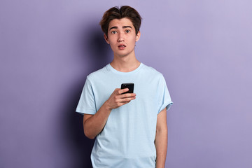 unhappy sad depressed man has received sms with bad news, guy has problems with mobile phone, close up portrait, isolated blue background