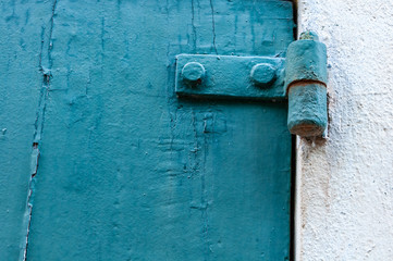 Door made of wooden panels painted and eroded by time, in a rural house, Italy.