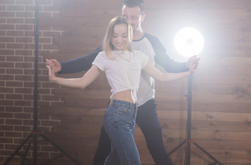Young couple dancing latin dance bachata, merengue, salsa, kizomba. Two expressive pose over wooden background