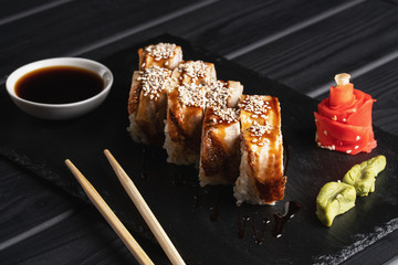 Japanese menu. Sushi roll on a black background.