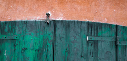 Door made of wooden panels painted and eroded by time, in a rural house, Italy.