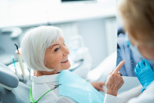 Smiling adult lady sitting in dental chair