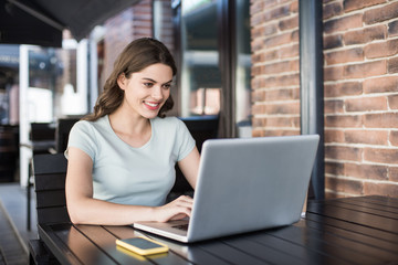 Woman using laptop indoors. Young beautiful girl working on computer. Entrepreneur, businesswoman, freelance worker, student typing on keyboard