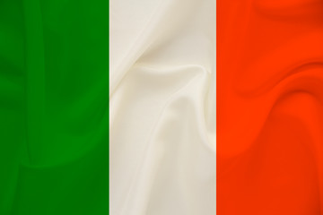 Obraz premium national flag of the country ireland on delicate silk with wind folds, travel concept, immigration, politics, copy space, close-up
