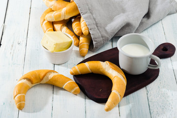 cup of milk and crescent rolls on white wooden © tstock