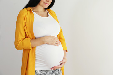 Cropped shot of young beautiful woman on third trimester of pregnancy. Close up of pregnant female...