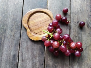 grape or red seedless grapes on wood background design concept in rustic