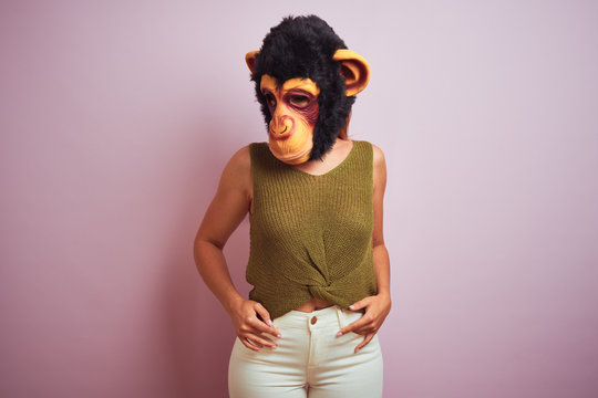 Woman standing wearing t-shirt and monkey mask