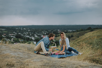 Happy young family is having picnic outdoors © Yakobchuk Olena