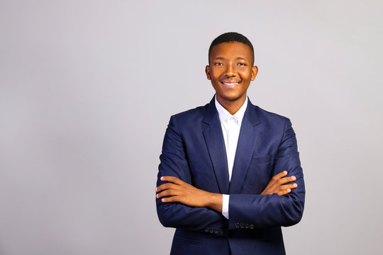Young handsome man of african american ethnicity wearing classic blue posing over isolated grey background. Portrait of stylish confident male in formal wear. Close up, copy space.