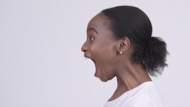 Closeup profile view of young beautiful African woman shouting and screaming