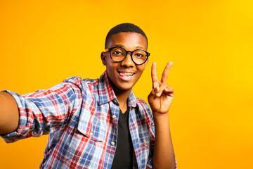 Young handsome man of african american ethnicity wearing checkered shirt posing over isolated background. Portrait of stylish confident male in casual outfit. Close up, copy space.